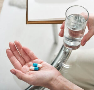 person taking migraine medication while exploring long-term migraine treatment physiotherapy management options