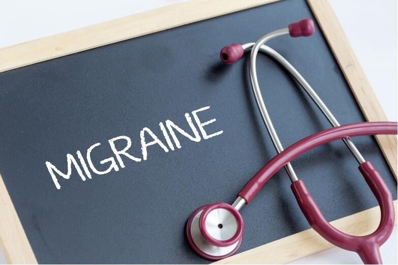 Chalkboard with 'Migraine' written beside a stethoscope, symbolising medical understanding of migraine and neck pain.