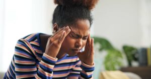 Young woman experiencing a headache at home